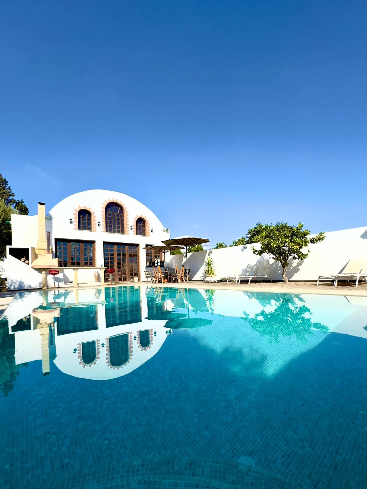 Swimming pool and whitewashed main building of the Trinity Soul retreat property in Nabeul, Tunisia